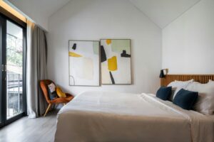 A bedroom with a large bed and a painting on the wall